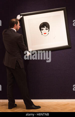 London, UK. 14 November 2016. Pictured: A Bonhams' employee hanging the screenprint Liza Minelli by Andy Warhol, est. GBP 20,000-30,000. Preview for Bonhams' forthcoming Prints & Multiples sales on 16 November. The line up includes works by artists including Lichtenstein, Warhol, Hockney and Hirst. Stock Photo