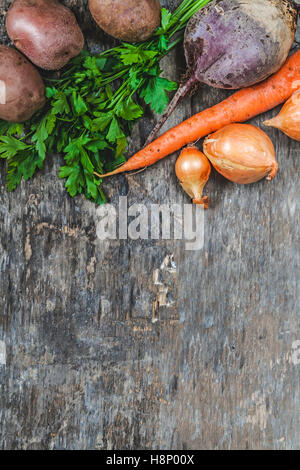potatoes, carrots, onions, parsley, beets raw on rustic background. Stock Photo