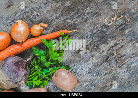 potatoes, carrots, onions, parsley, beets raw on rustic background. Stock Photo