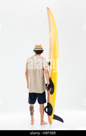 Back view a young surfer holding surfboard isolated on the white background Stock Photo