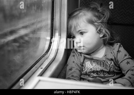 Cute innocent little girl traveling by train in England Stock Photo