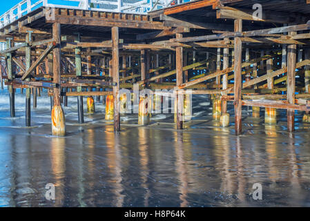 pier and pilings reflecting off of wet sand. Crystal Pier, San Diego, California, USA. Stock Photo