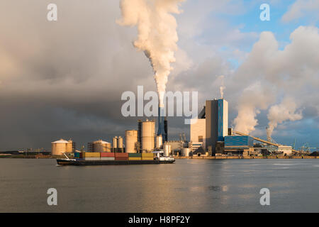 Smoke of heavy industry is highlighted by the sun. Shot in the Netherlands industry area of the Europoort in Rotterdam. Stock Photo