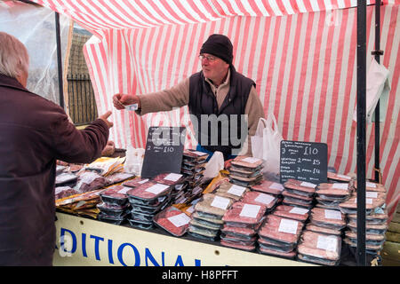 Stallholder selling home made Venison  sausages and wild Venison Steaks at a specialist farmer's market stall in North Yorkshire Stock Photo