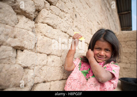 Maya indigenous girl brushes her hair in Caserio Panuca, Solola, Guatemala. Stock Photo