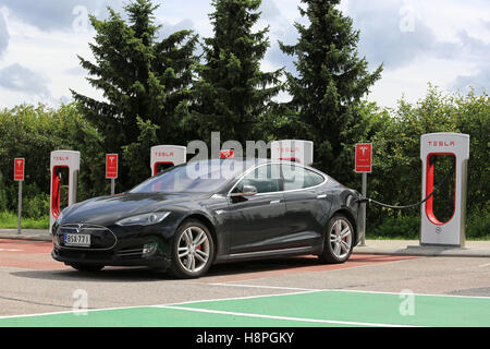 PAIMIO, FINLAND - JULY 17, 2016: Black Tesla Model S Electric car charging at Tesla Supercharger station in Paimio, Finland Stock Photo