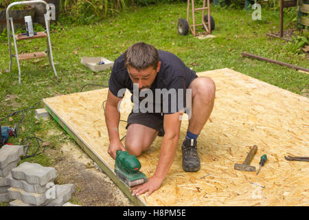 Worker grinds the wood of angular grinding machine, Polishing the wood Stock Photo