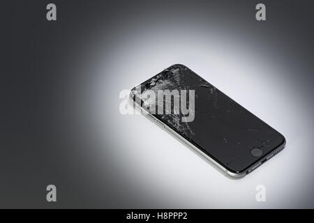 a mobile phone with broken screen on a gradient background Stock Photo