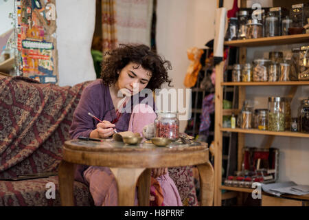 Asian woman writes dealer price tag on the goods in the store Stock Photo