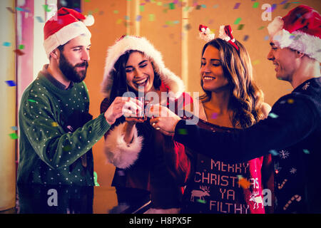 Composite image of festive friends having shots Stock Photo