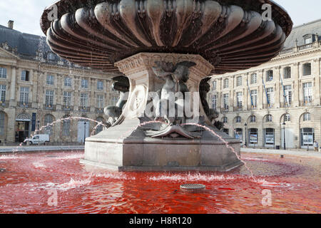 Fountain of the Three Graces with red water on the Place de la Bourse in Bordeaux, Gironde department, France. Stock Photo