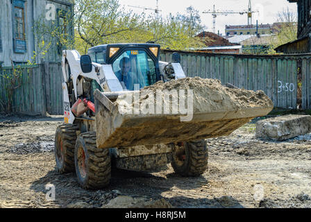 Skid loader on road construction Stock Photo