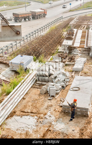 Worker levels provision of plate lifting by crane Stock Photo