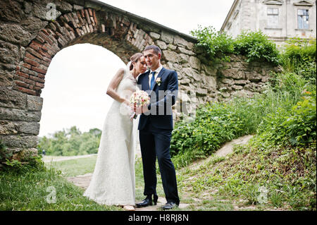 Wedding couple under arch of gate of old castle. Stock Photo