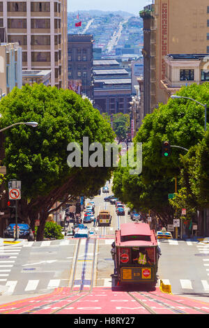 Iconic cable car traveling downhill on Powell Street with Union Square and downtown Market Street in background Stock Photo