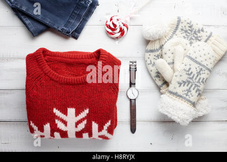 Christmas clothing style set with winter knitted sweater, jeans, cap, mittens, watches and lollipop. Stock Photo