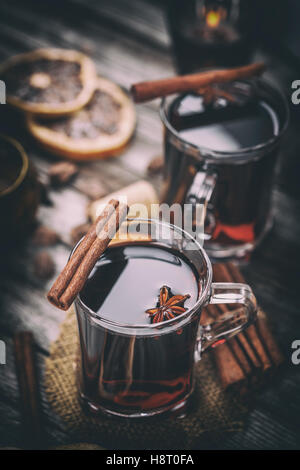 Hot mulled wine in a glass with dry orange slices, anise and cinnamon sticks Stock Photo