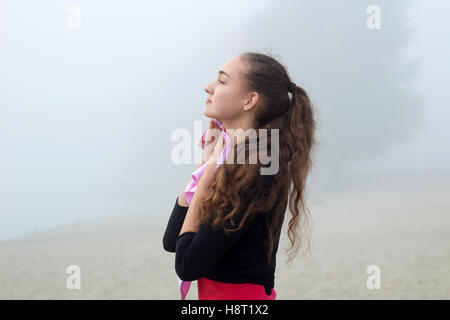 Young pretty slim fitness sporty woman with towel during break at training workout outdoor Stock Photo