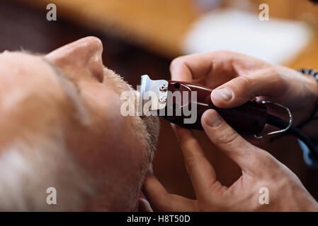 Top view of senior man getting his mustache trimmed Stock Photo