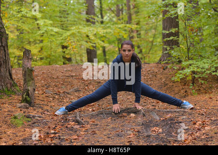 Energetic young woman do exercises outdoors in park to keep their bodies in shape. Fitness concept. Body-building theme. Sport m Stock Photo