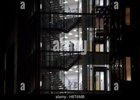 nighttime after hours office glass silhouettes stairs Stock Photo