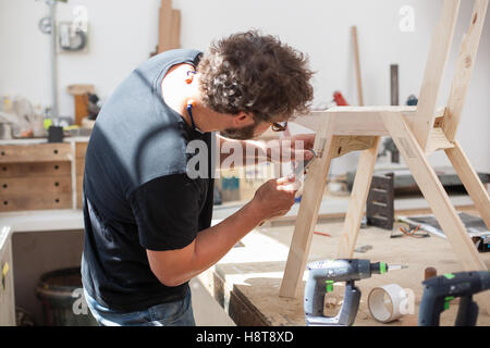 Furniture designer maker working in his workshop Stock Photo