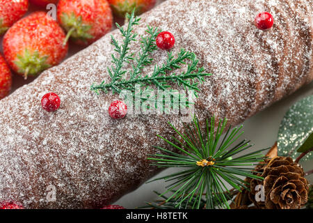 Close up shot of a frosted chocolate christmas log with strawberries Stock Photo