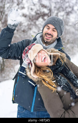 Couple having fun in a snow covered park Stock Photo