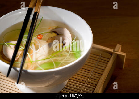 Chicken soup with vegetables in bowl with chop sticks Stock Photo