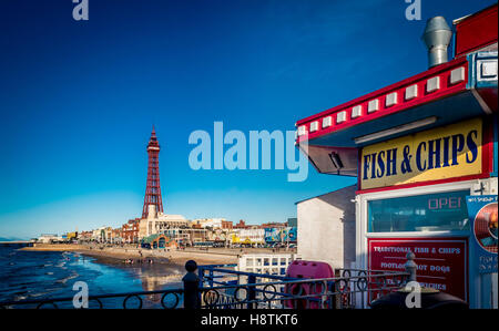 FISH AND CHIPS sign on Central Pier with Blackpool Tower in distance, Blackpool, Lancashire, UK. Stock Photo