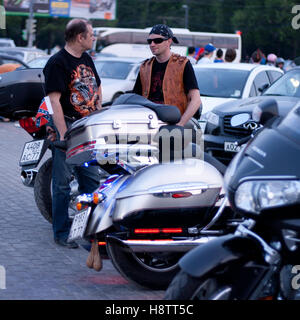 MOSCOW, RUSSIA - OCTOBER 6, 2013: Biker in a bandana  talking with a balding man in a black T-shirt with dragon. Stock Photo