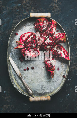 Fresh ripe pomegranate broken in pieces in metal tray Stock Photo