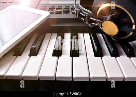 Electronic piano with headphones and tablet in studio. Horizontal Composition.Front view Stock Photo