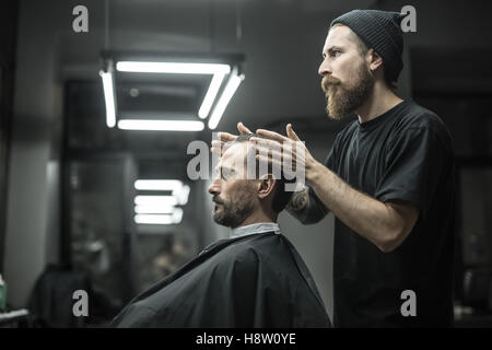 Making hairstyle in barbershop Stock Photo
