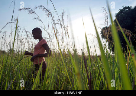 South Sudan refugee walking a field in North Uganda, near the town of Adjumani. Nov, 2016 Stock Photo