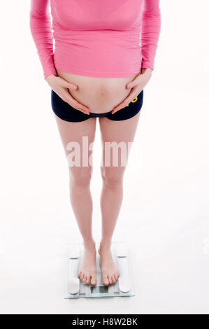 Pregnant woman standing on scales Stock Photo