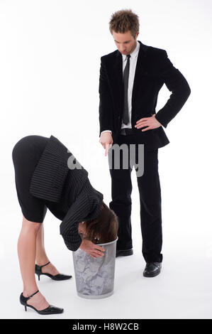 Photo of a businessman bending over to get something out of a drawer as ...