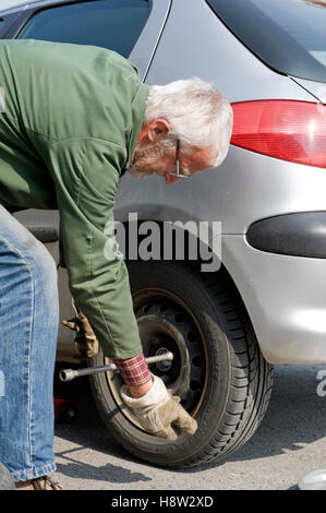 Retiree changing tires Stock Photo