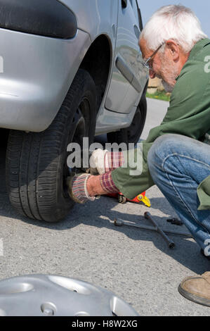 Senior changing tires Stock Photo