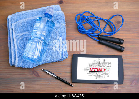MOTIVATION word cloud, fitness, sport, health concept. On tablet device on a wooden table Stock Photo