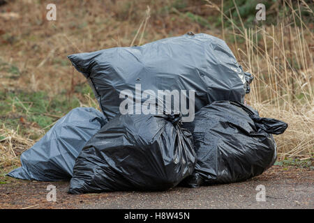 pile black garbage bag plastic and four dustbin dirty roadside in the city  with copy space add text Stock Photo - Alamy