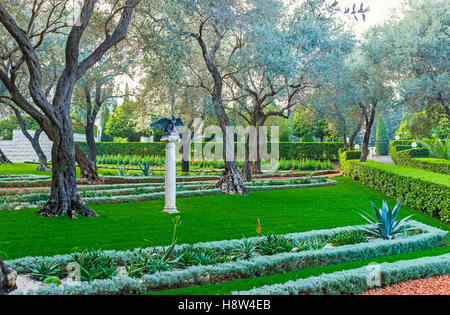 The small sculpture of the eagle, waving his wings, in shade of trees in Bahai Garden, Haifa, Israel. Stock Photo