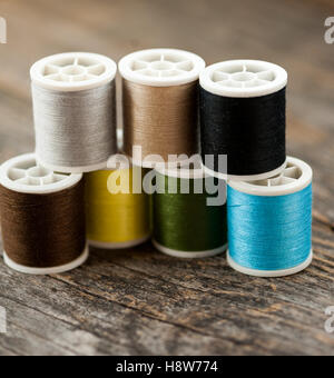 Multi-colored threads on a wooden table Stock Photo