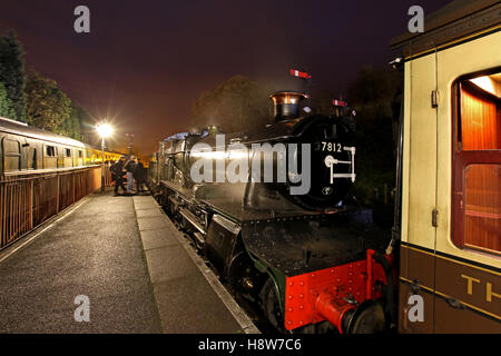 Night scene at Shropshire tourist attraction Severn Valley Railway as steam locomotive 7812 awaits passengers at Bridgnorth station after dark Stock Photo