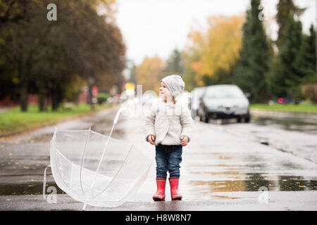 Little girl with transparent umbrella outside, rainy day. Stock Photo