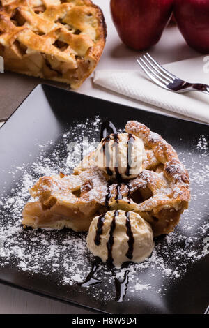 fresh baked apple pie slice with icecream on black plate Stock Photo