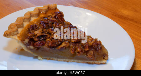 Slice of pecan pie that is on a white plate Stock Photo