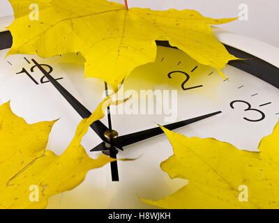 Fall back, winter time. Clock face with viburnum and leaves. Stock Photo