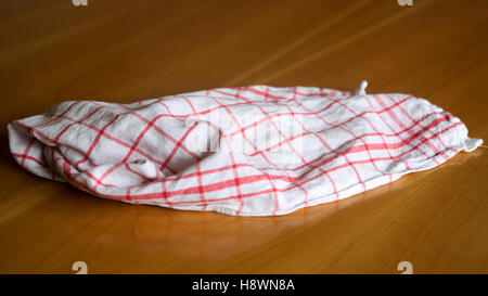 white red checkered wrinkled dishcloth on a wooden table Stock Photo