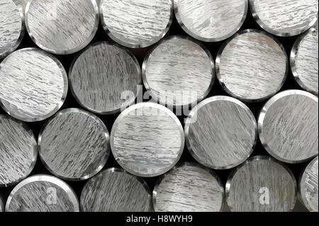 Background texture and pattern of aluminium bars with focus to the cut and bevelled ends of the round metallic silver rods in a Stock Photo